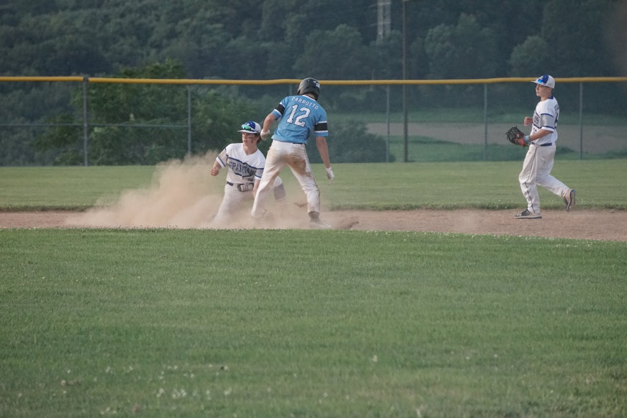 services-03 Exciting moment captured at a youth baseball game with players sliding on the dusty field.